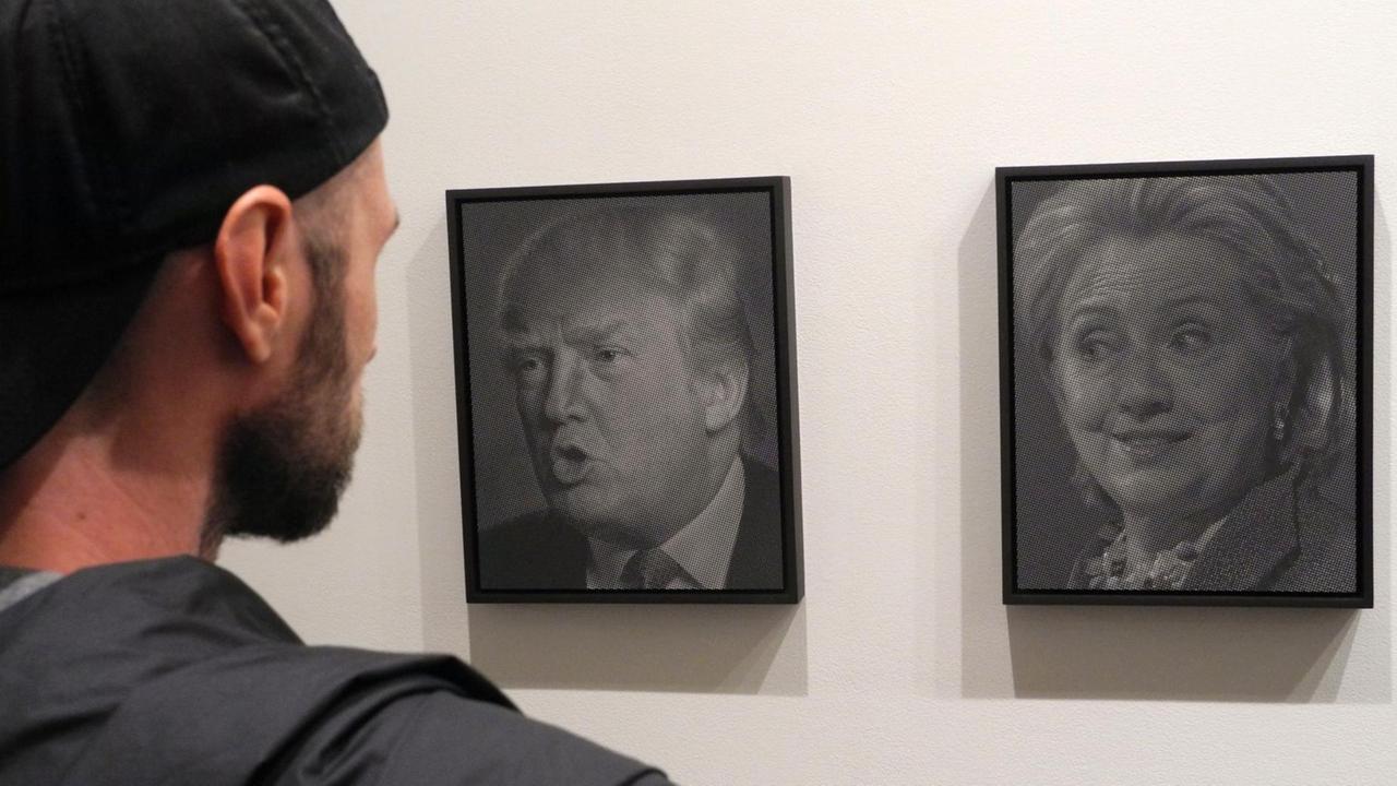Besucher betrachten am 13.10.2016 die Porträts "Trump (Clinton)" (l) und "Clinton (Trump)" (r) des Künstlers Alfred Steiner in der Ausstellung «Why I Want to Fuck Donald Trump» in der Joshua Liner Gallery in New York (USA). Besucher betrachten am 13.10.2016 die Porträts "Trump (Clinton)" (l) und "Clinton (Trump)" (r) des Künstlers Alfred Steiner in der Ausstellung «Why I Want to Fuck Donald Trump» in der Joshua Liner Gallery in New York (USA).