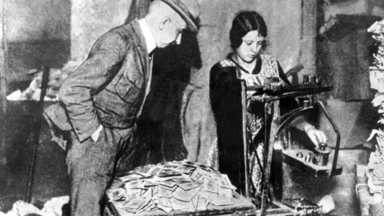 Geldscheine, die während der Inflation 1923 nur noch Makulatur sind, werden gewogen.