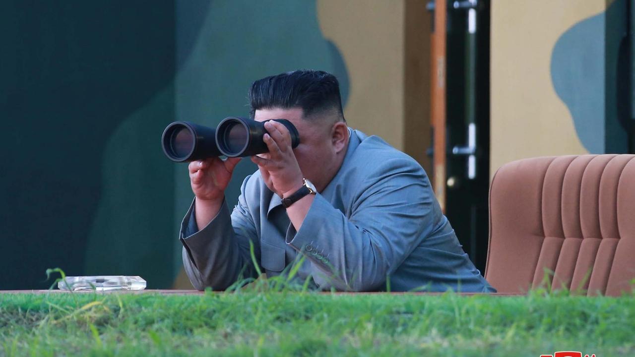 Nordkoreas Machthaber Kim Jong Un beobachtet mit einem Fernglas einen Raketentest. Nordkoreas Machthaber Kim Jong Un beobachtet mit einem Fernglas einen Raketentest.