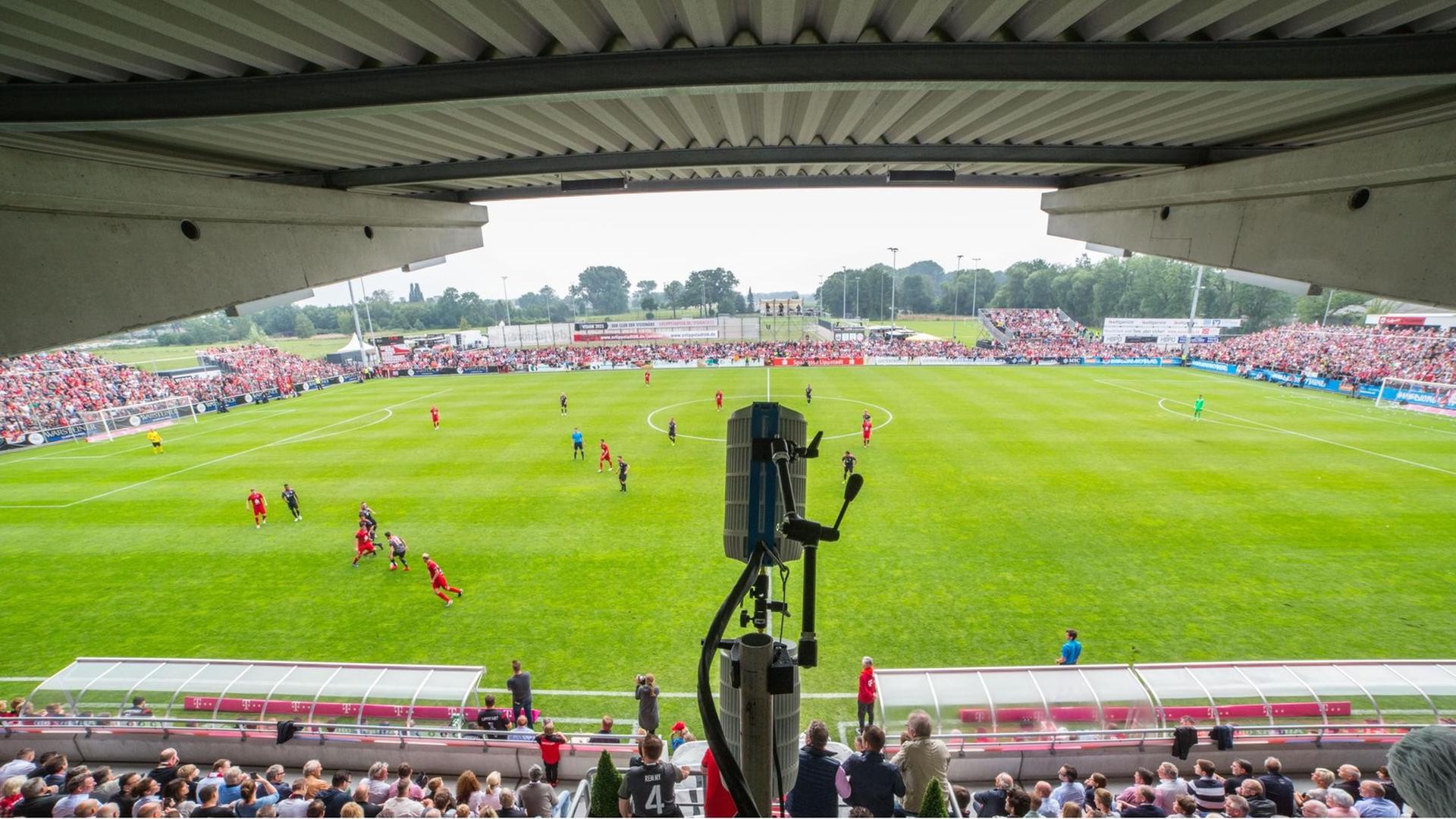 Ein runder Kasten hängt über der Tribüne mit Blick auf das Fußballfeld Ein runder Kasten hängt über der Tribüne mit Blick auf das Fußballfeld