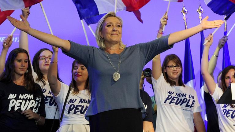 Marine Le Pen, Vorsitzende des rechtsextremen Front National, steht bei einem Kongress der Partei im südfranzösischen Frejus mit ausgebreiteten Armen auf der Bühne.