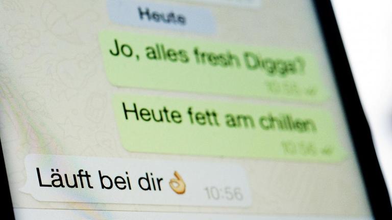 Ein fiktiver Dialog mit dem Satz "Läuft bei dir" ist auf einem Smartphone-Display in dem Messenger WhatsApp zu sehen. Ein fiktiver Dialog mit dem Satz "Läuft bei dir" ist auf einem Smartphone-Display in dem Messenger WhatsApp zu sehen.