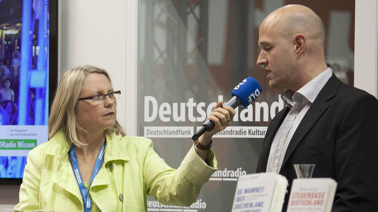 Markus Meinzer (r.) im Gespräch mit DLF-Redakteurin Jule Reimer auf der Frankfurter Buchmesse 2015. Markus Meinzer (r.) im Gespräch mit DLF-Redakteurin Jule Reimer auf der Frankfurter Buchmesse 2015.