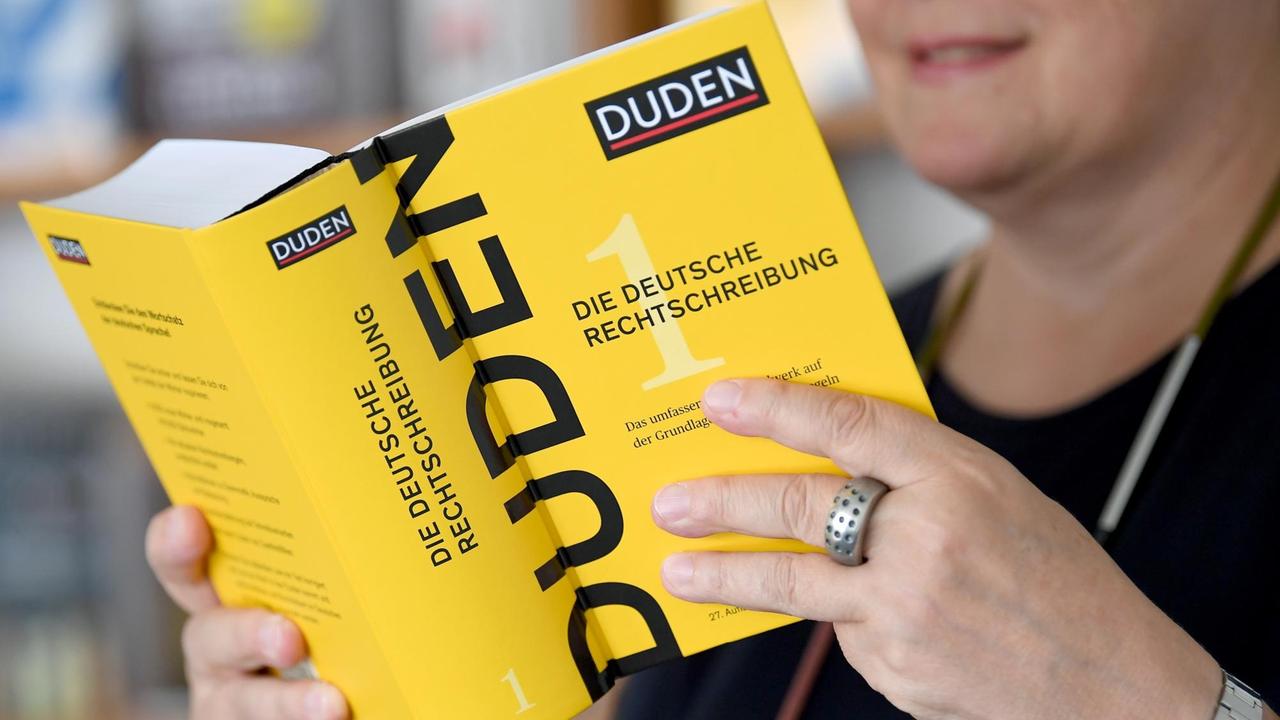 Die Leiterin der Dudenredaktion Kathrin Kunkel-Razum hält einen Duden der 27. Auflage in der Hand.