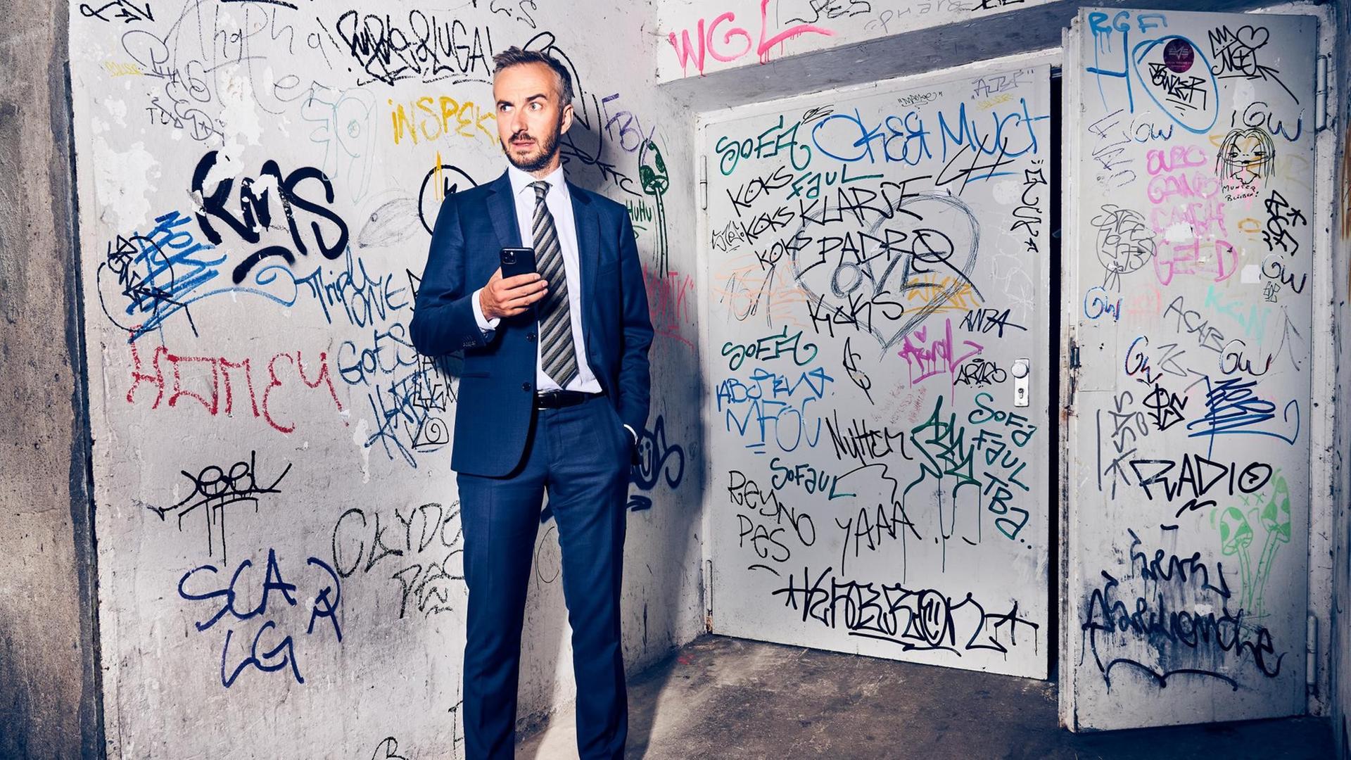 Porträt von Jan Böhmermann in einem mit Graffiti beschmierten Treppenhaus. Porträt von Jan Böhmermann in einem mit Graffiti beschmierten Treppenhaus.