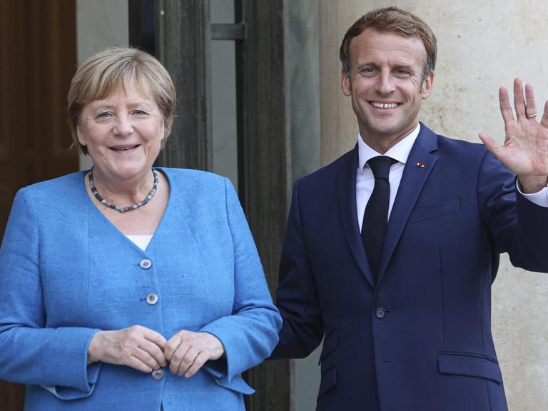 Frankreichs Präsident Emmanuel Macron begrüßt Bundeskanzlerin Angela Merkel vor dem Elysee Palast.