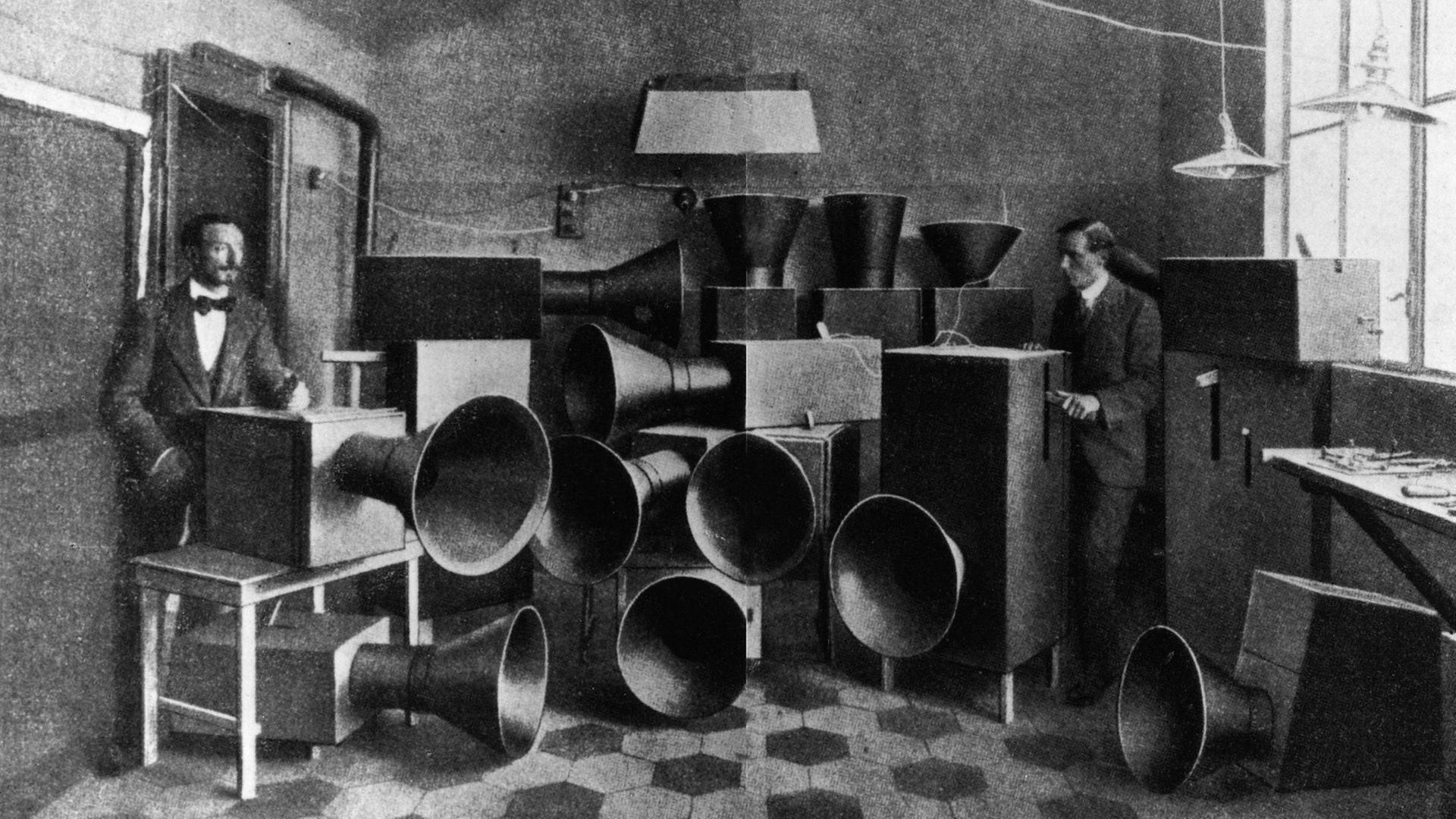 Luigi Russolo und sein Assistent Piatti mit den Intonarumori-Geräuschmaschinen 1914. Das Intonarumori oder "Instrument zur Erzeugung von Geräuschen" wurde 1913 vom futuristischen Komponisten Luigi Russolo (1885 1947) entwickelt. Luigi Russolo und sein Assistent Piatti mit den Intonarumori-Geräuschmaschinen 1914. Das Intonarumori oder "Instrument zur Erzeugung von Geräuschen" wurde 1913 vom futuristischen Komponisten Luigi Russolo (1885 1947) entwickelt.