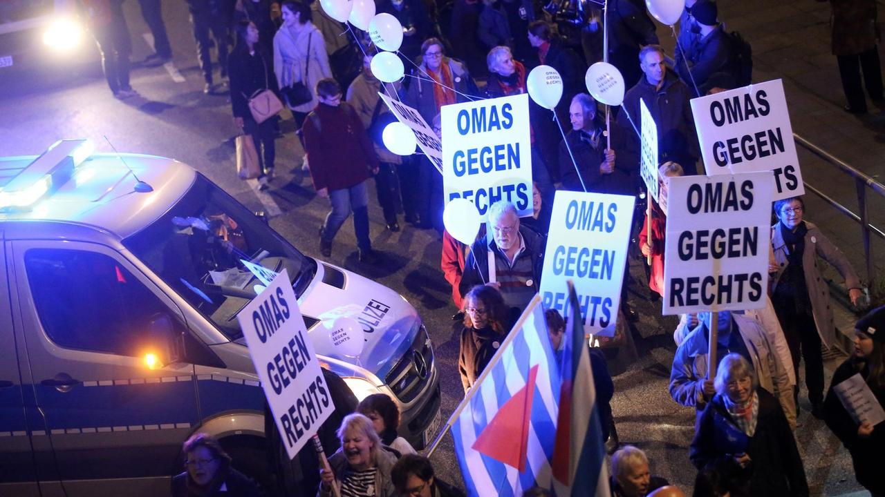 Gegendemonstranten der Veranstaltung "Merkel muss weg!" tragen Pappschilder mit der Aufschrift "Omas gegen Rechts".