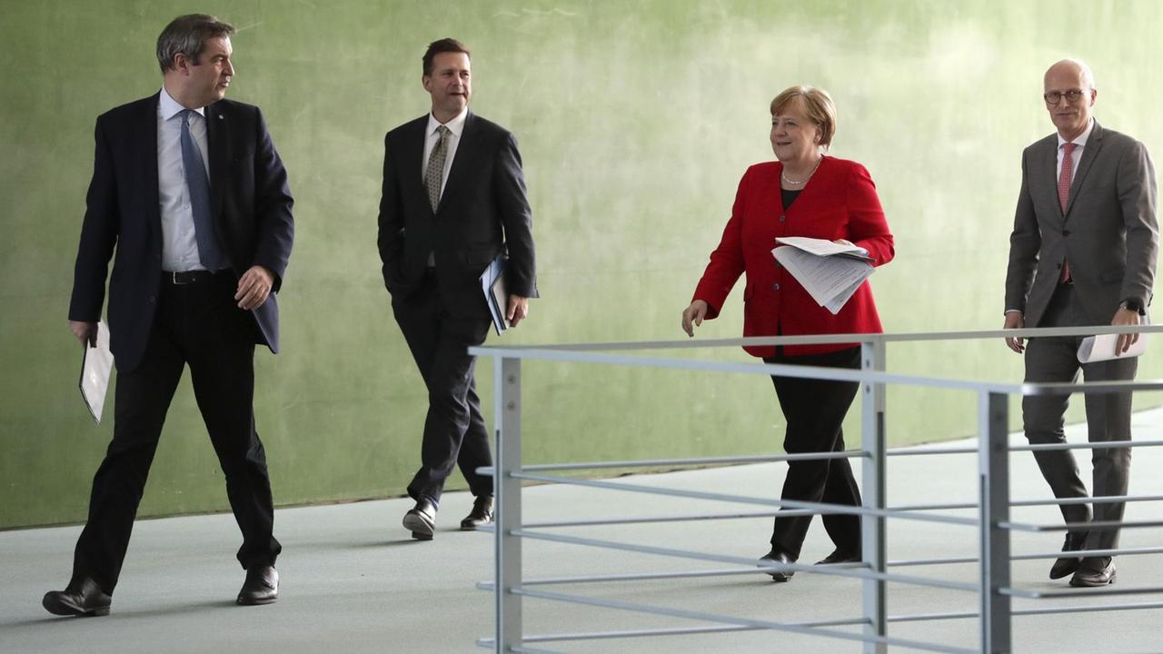 Bundeskanzlerin Angela Merkel (CDU, 2.v.r.) Markus Söder (CSU, l.), Ministerpräsident von Bayern, Peter Tschentscher (SPD, r.), Erster Bürgermeister von Hamburg und Regierungssprecher Steffen Seibert (2.v.l.) vor einer gemeinsamen Pressekonferenz. Bundeskanzlerin Angela Merkel (CDU, 2.v.r.) Markus Söder (CSU, l.), Ministerpräsident von Bayern, Peter Tschentscher (SPD, r.), Erster Bürgermeister von Hamburg und Regierungssprecher Steffen Seibert (2.v.l.) vor einer gemeinsamen Pressekonferenz.