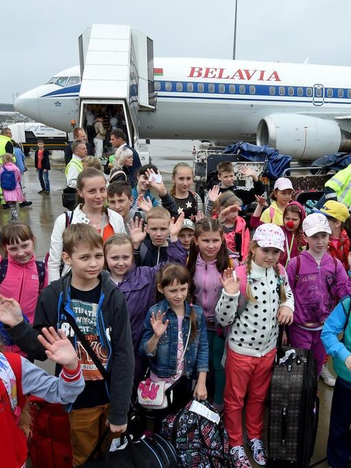 Kinder winken auf dem Flughafen Hannover-Langenhagen (Niedersachsen) zur Begrüßung, nachdem sie zuvor aus der Republik Belarus (Weissrussland) eingetroffen sind