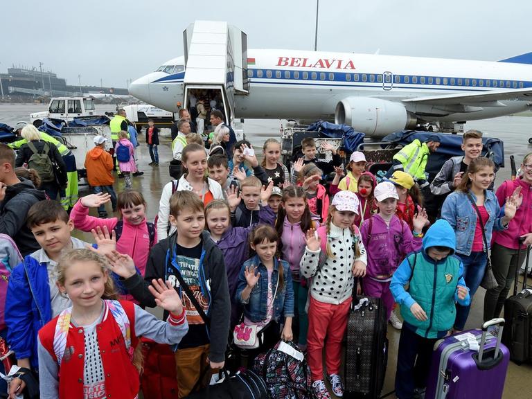 Kinder winken auf dem Flughafen Hannover-Langenhagen (Niedersachsen) zur Begrüßung, nachdem sie zuvor aus der Republik Belarus (Weissrussland) eingetroffen sind