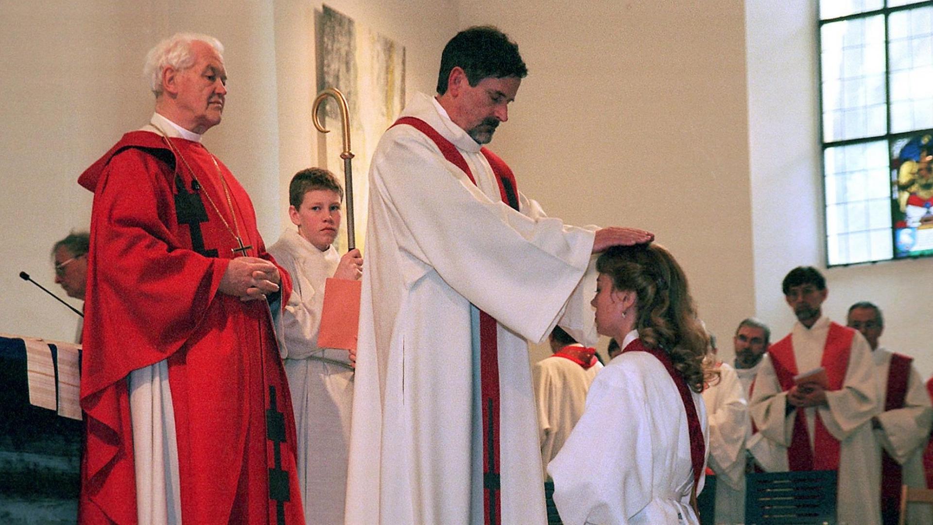 Nachdem Denise Wyss (34, knieend) am 19.2.2000 in der Franziskanerkirche in Solothurn (Schweiz) vom ehemaligen Erzbischof von Utrecht, Antonius Jan Glazemaker (l), zur ersten christkatholischen (altkatholischen) Priesterin der Schweiz geweiht wurde, legen ihr christkatholische Priester zum Segen die H Nachdem Denise Wyss (34, knieend) am 19.2.2000 in der Franziskanerkirche in Solothurn (Schweiz) vom ehemaligen Erzbischof von Utrecht, Antonius Jan Glazemaker (l), zur ersten christkatholischen (altkatholischen) Priesterin der Schweiz geweiht wurde, legen ihr christkatholische Priester zum Segen die H