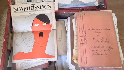Ausschnitte aus einer Zeitschrift auf einer roten Kiste Ausschnitte aus einer Zeitschrift auf einer roten Kiste