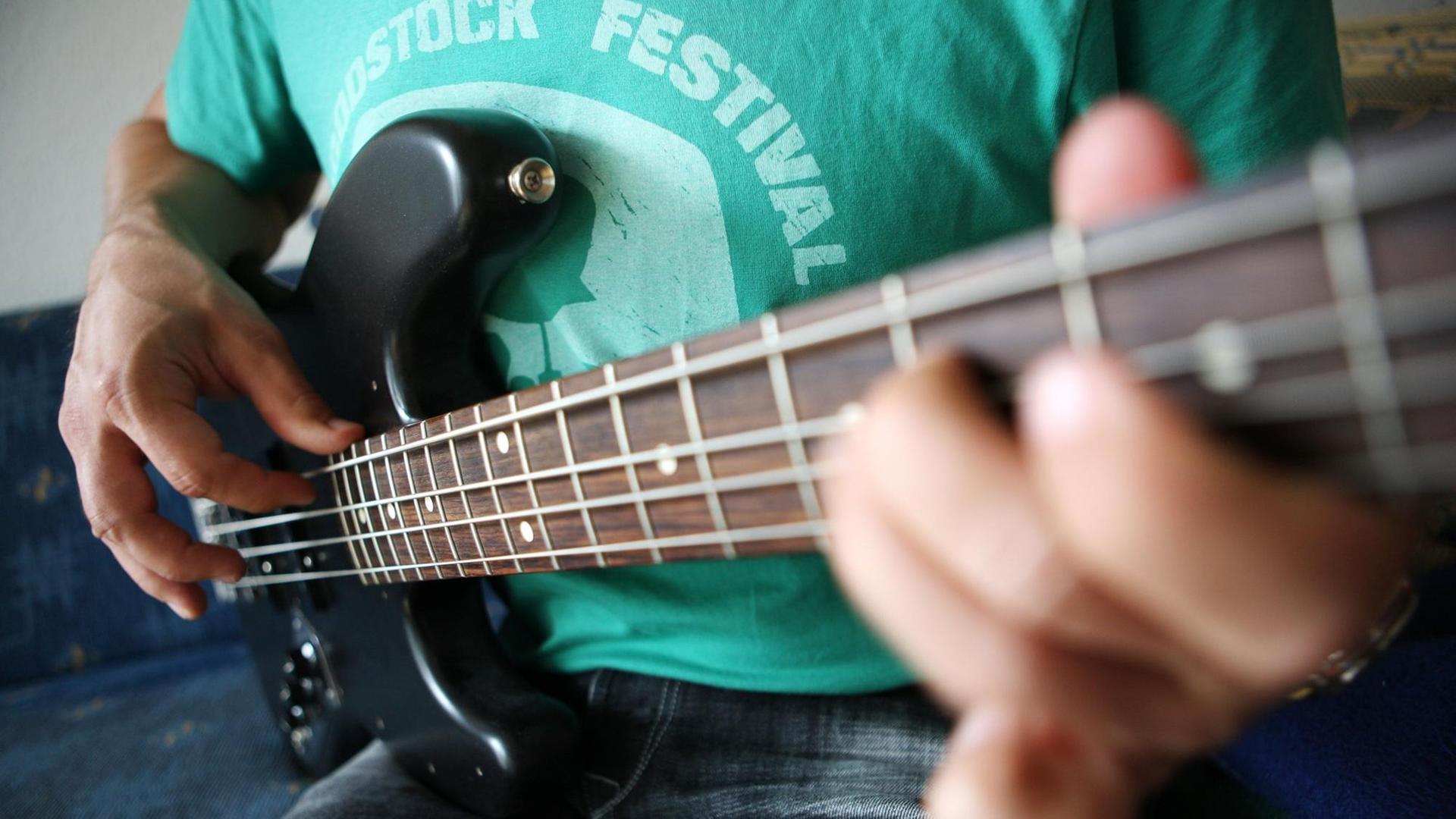 Ein Bassist spielt in Köln auf einem elektrischen Bass Ein Bassist spielt in Köln auf einem elektrischen Bass