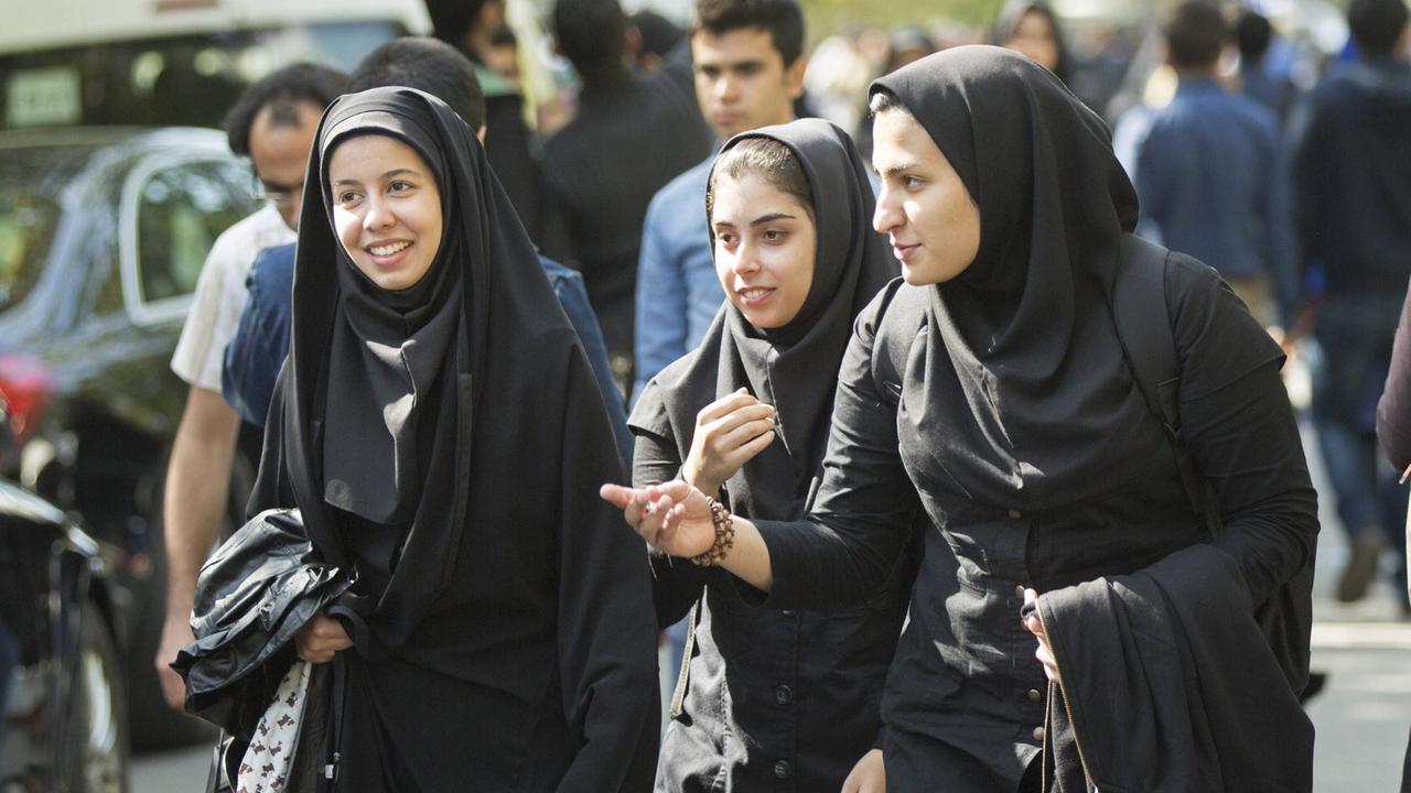 Studentinnen und Studenten laufen an der Universitaet in Teheran über den Campus Teheran.