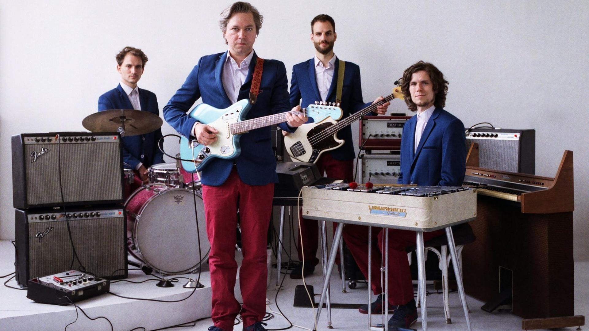 Vier Musiker posieren mit ihren Instrumenten Vier Musiker posieren mit ihren Instrumenten