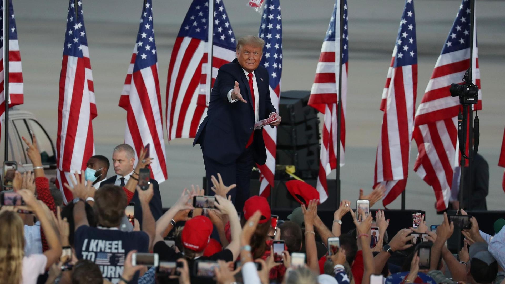 Präsident Trump wirft einen Gegenstand in die Menschenmenge auf seinem ersten öffentlichen Auftritt nach seiner Coronavirusinfektion Präsident Trump wirft einen Gegenstand in die Menschenmenge auf seinem ersten öffentlichen Auftritt nach seiner Coronavirusinfektion
