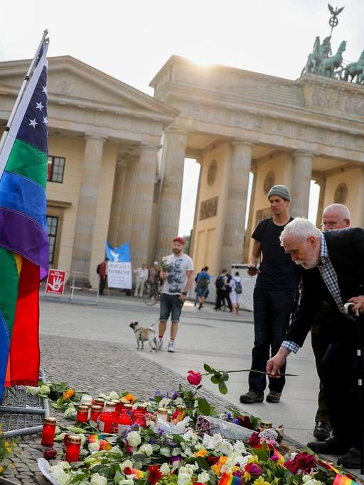 Passanten legen am 13.06.2016 in Berlin vor der Botschaft der USA am Brandenburger Tor im Gedenken der Opfer des Attentats in Orlando Blumen nieder.