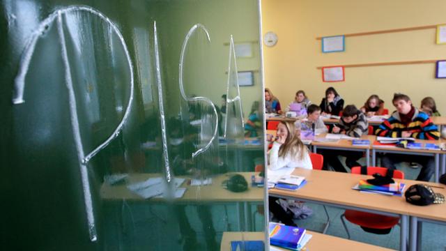 IILLUSTRATION - Das Wort "PISA" steht am Montag (06.12.2010) an einer Hauptschule in Arnsberg (Sauerland) auf einer Schultafel, während Schüler den Unterricht verfolgen. Fast eine halbe Millionen 15-Jähriger machte mit. Am Dienstag wird die neue Studie vo