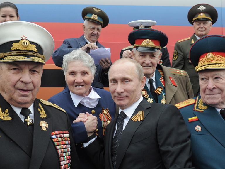Der russische Präsident Vladimir Putin und Veteranen des Großen Vaterländischen Krieges, am 9. Mai 2012 bei der Siegesparade auf dem Roten Platz in Moskau