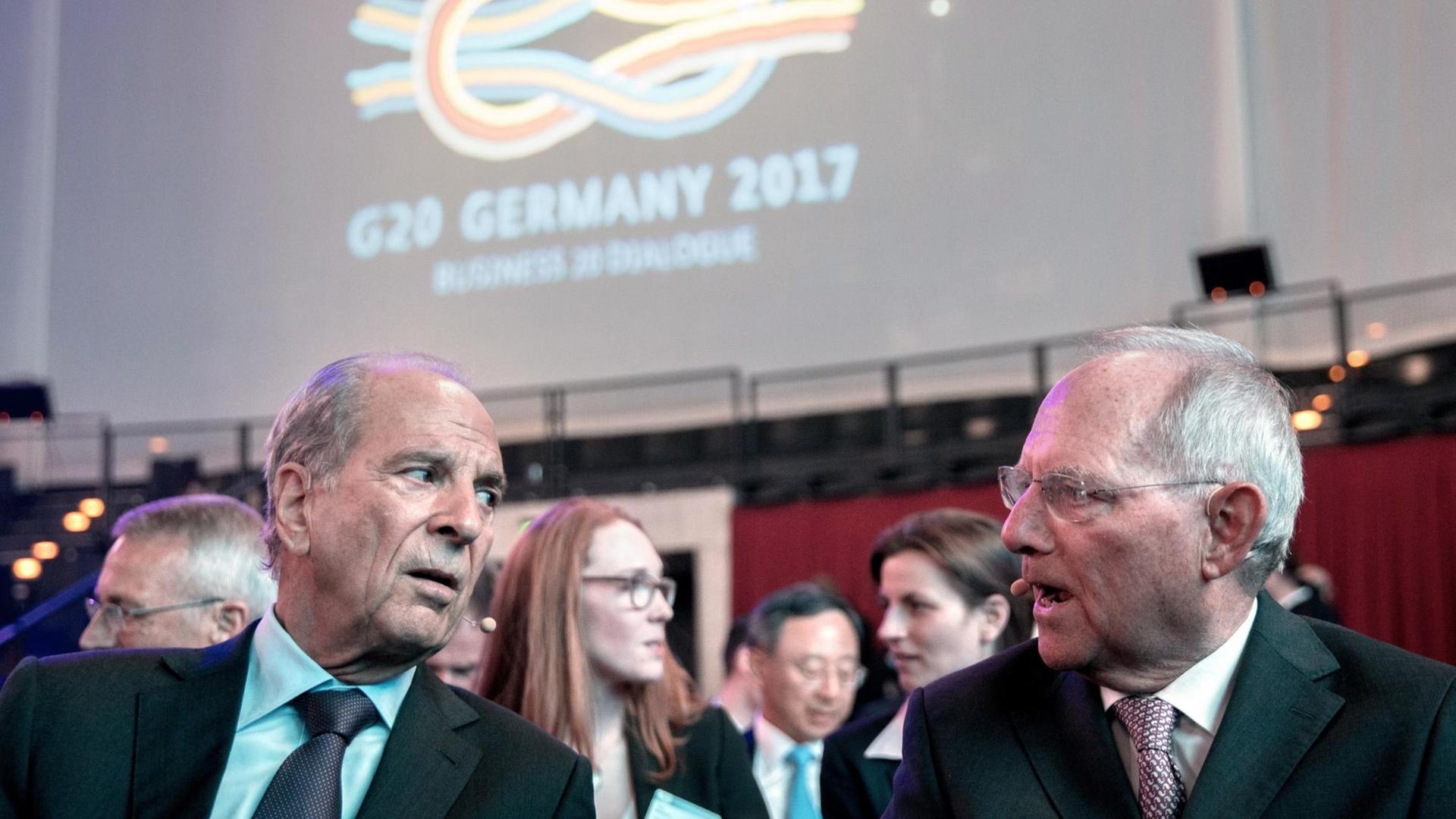 Bundesfinanzminister Wolfgang Schäuble (CDU, r) und Gastgeber Jürgen Heraeus unterhalten sich am 02.05.2017 in Berlin beim Treffen von Wirtschaftsverbänden "Business20 (B20)" im Rahmen der deutschen G20-Präsidentschaft. Foto: Kay Nietfeld/dpa | Verwendung weltweit