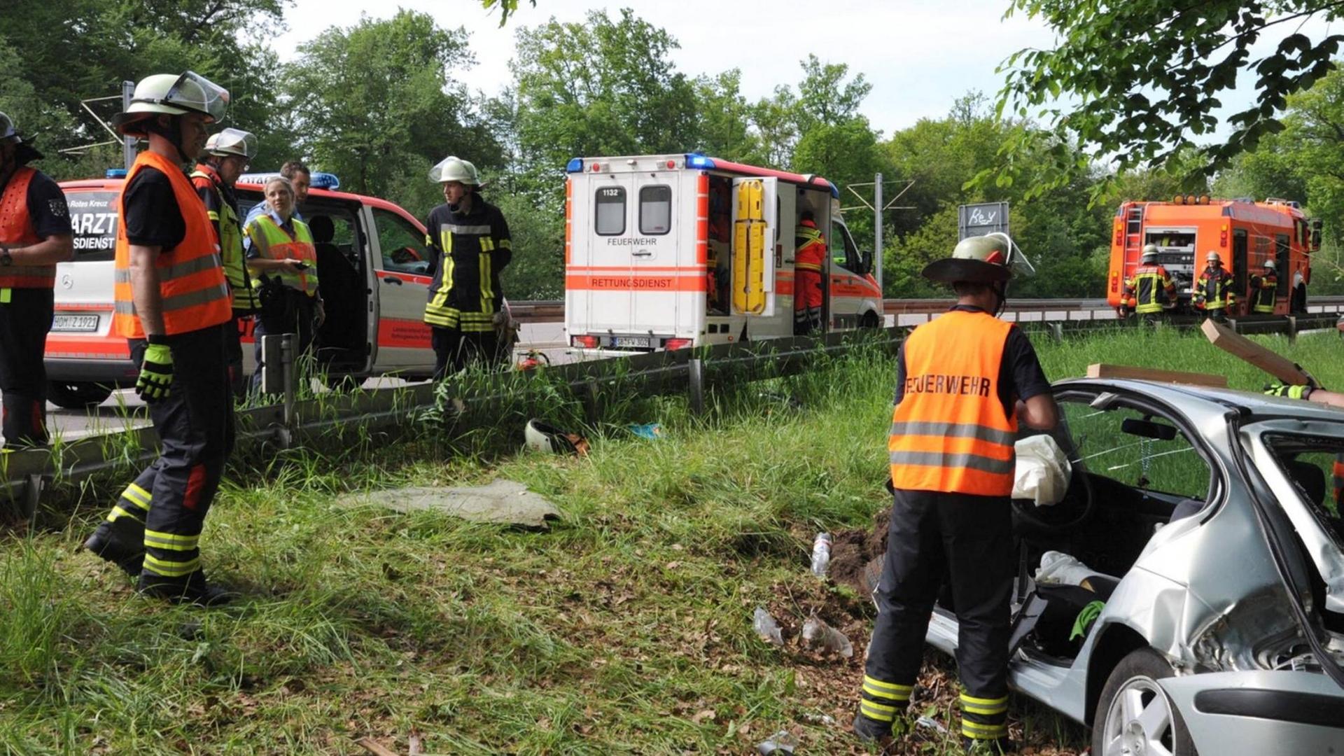 Farbfoto eines Unfallautos auf der Autobahn. Die Feuerwehr befreit den Mann aus seinem Auto. Farbfoto eines Unfallautos auf der Autobahn. Die Feuerwehr befreit den Mann aus seinem Auto.