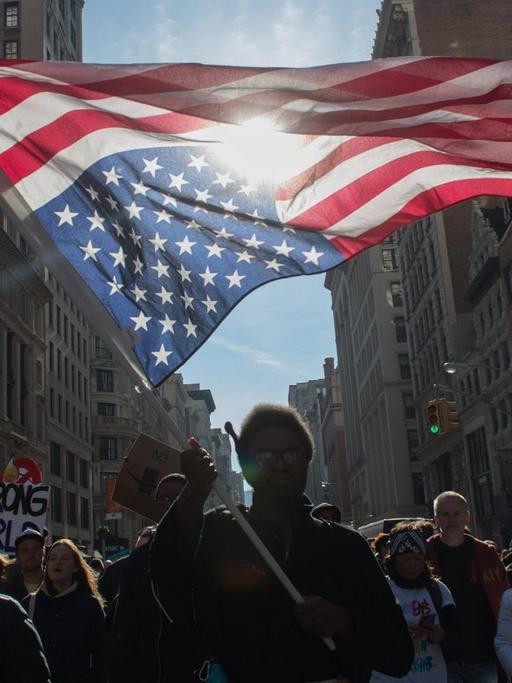 Ein Demonstrant hält eine auf dem Kopf stehende US-Flagge während einer Demonstration