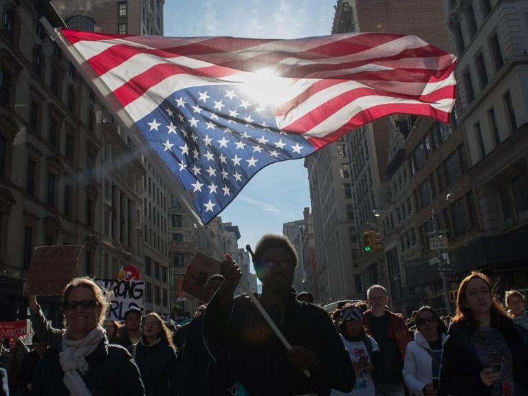 Ein Demonstrant hält eine auf dem Kopf stehende US-Flagge während einer Demonstration