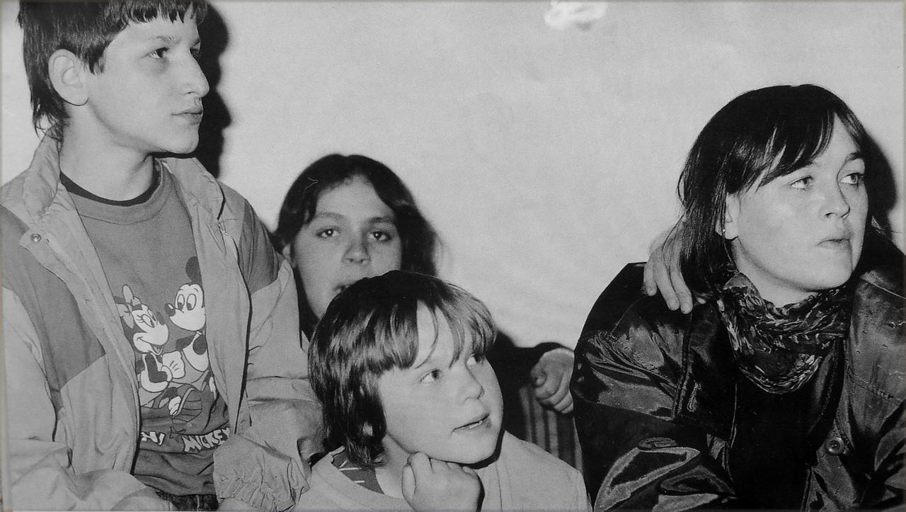 Ein altes Schwarz-Weiß-Foto zeigt Kinderheimleiterin Sibylle Hüttemann mit Straßenkindern am Bukarester Nordbahnhof. 