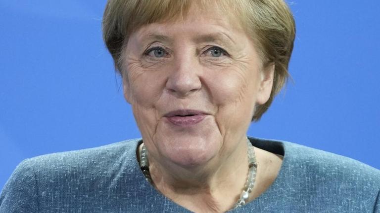Potrrät von Bundeskanzlerin Angela Merkel vor blauem Hintergrund.