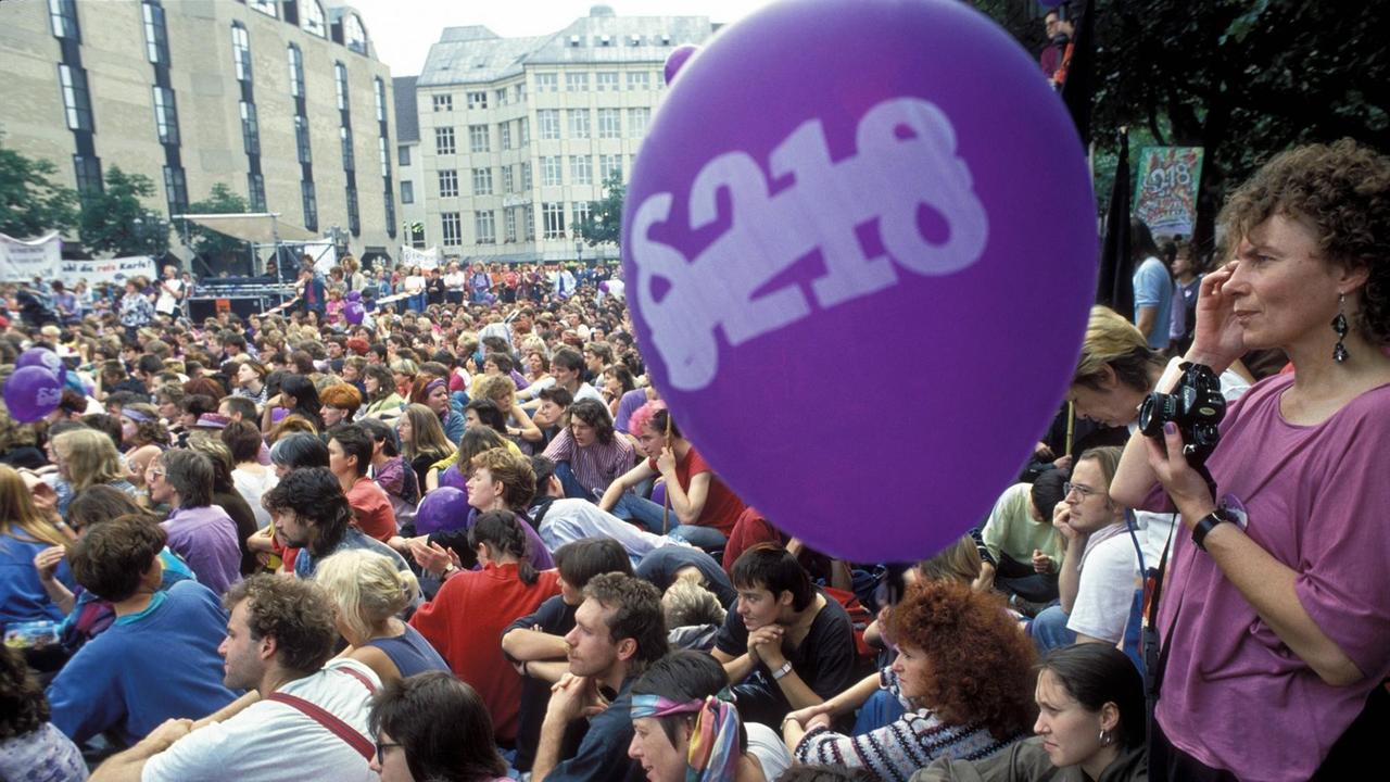 Viele Menschen demonstrieren in  Bonn gegen den Paragrafen 218. Im Vordergrund ist ein lila-farbener Ballon zu sehen, auf dem der Paragraf 218 durchgestrichen ist.