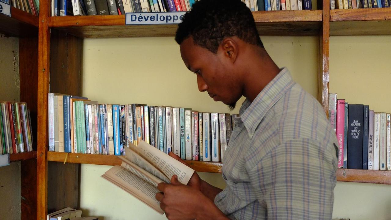 Student Barry sucht in der Bibliothek in Conakry (Guinea) ein Buch für sein Seminar
