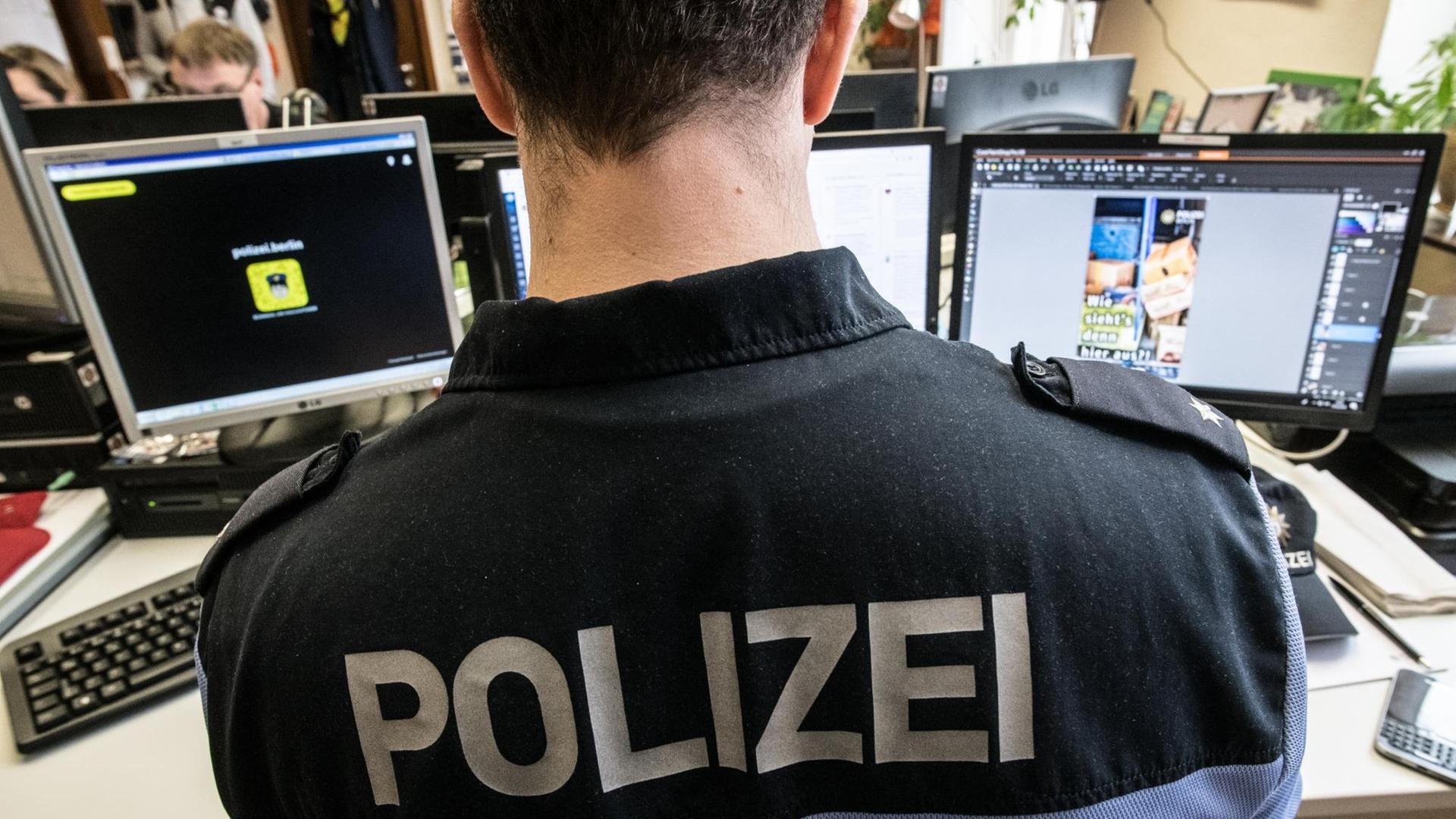 Ein Mitarbeiter des Social Media Teams der Polizei sitzt in einem Raum im Polizeipräsidium vor seinen Computern. Ein Mitarbeiter des Social Media Teams der Polizei sitzt in einem Raum im Polizeipräsidium vor seinen Computern.