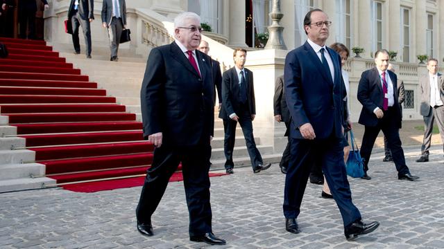 Frankreichs Präsident Francois Hollande (r.) und sein irakischer Amtskollege Fuad Masum passieren am 15. September 2014 den Weg vor dem französischen Außenministerium in Paris nach der Eröffnung einer internationalen Konferenz zur Lage im Irak.