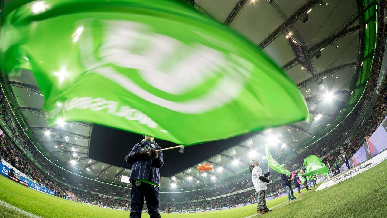 Im Stadion des Bundesligisten VfL Wolfsburg wird eine große Vereinsfahne geschwenkt. 