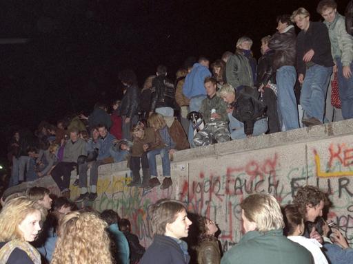 Einen Tag nach der Grenzöffnung in Berlin feiern tausende Menschen auf, vor und hinter der Berliner Mauer am Brandenburger Tor, aufgenommen am 10. November 1989 auf West-Berliner Seite. Die innerdeutsche Grenze, die das Land seit 1961 geteilt hat, hört praktisch auf zu existieren. Es wird allerdings noch mehrere Wochen dauern, bis auch am Brandenburger Tor, dem Berliner Wahrzeichen, die Mauer für einen Grenzübergang geöffnet wird. | Verwendung weltweit