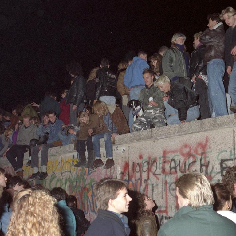 Einen Tag nach der Grenzöffnung in Berlin feiern tausende Menschen auf, vor und hinter der Berliner Mauer am Brandenburger Tor, aufgenommen am 10. November 1989 auf West-Berliner Seite. Die innerdeutsche Grenze, die das Land seit 1961 geteilt hat, hört praktisch auf zu existieren. Es wird allerdings noch mehrere Wochen dauern, bis auch am Brandenburger Tor, dem Berliner Wahrzeichen, die Mauer für einen Grenzübergang geöffnet wird. | Verwendung weltweit