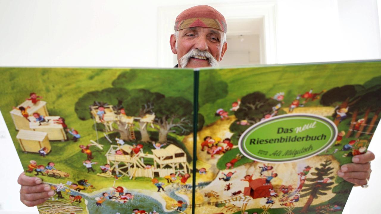 Ali Mitgutsch (hier im Bilderbuchmuseum in Troisdorf) ist gestorben. Auf dem Foto hält er eines seiner Wimmelbücher in der Hand. Ali Mitgutsch (hier im Bilderbuchmuseum in Troisdorf) ist gestorben. Auf dem Foto hält er eines seiner Wimmelbücher in der Hand.