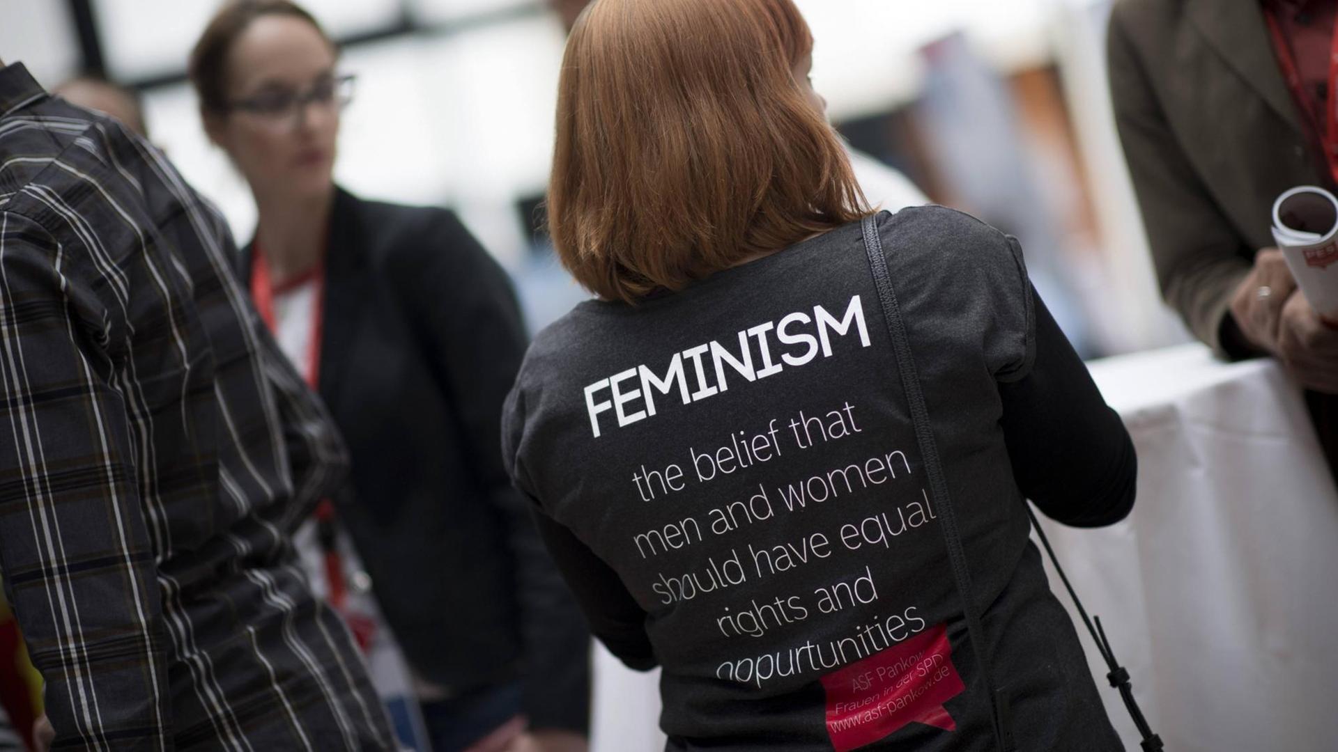 Frau mit schwarzem T-Shirt und Aufdruck "Feminism" Frau mit schwarzem T-Shirt und Aufdruck "Feminism"