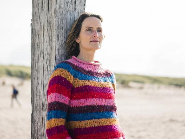 Eine Frau entspannt am Strand.
