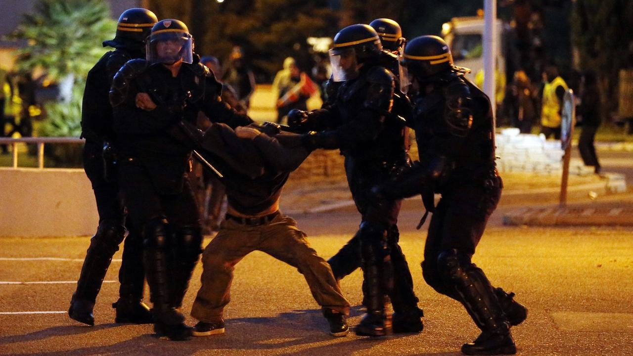 Polizisten nehmen einen Aktivisten fest, der sich wehrt.
