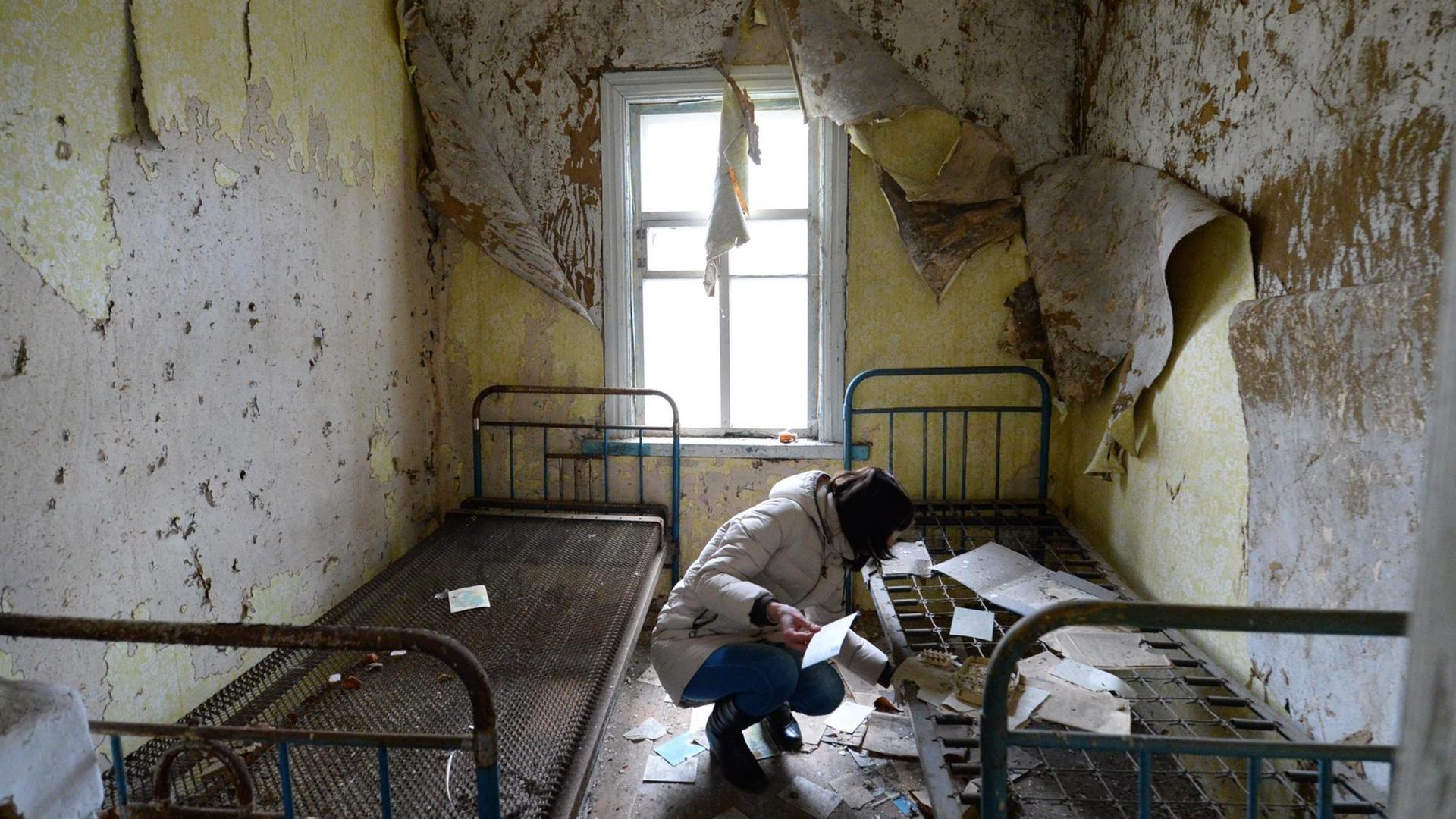 Eine Frau in ihrem verlassenen Haus in Tschernobyl: Die Menschen mussten von einem Tag auf den anderen alles hinter sich lassen.