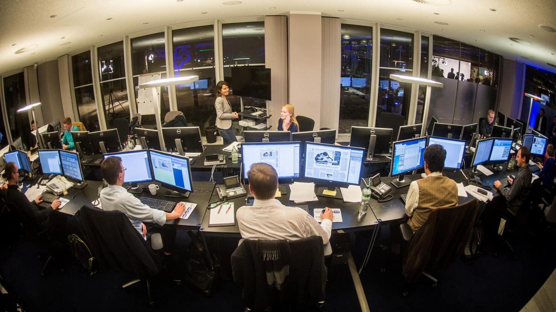 Ein Dutzend Mitarbeiter des Redaktionsnetzwerks Deutschland (RND) sitzen im provisorischen Madsack-Newsroom an Schreibtischen vor ihren Bildschirmen. Ein Dutzend Mitarbeiter des Redaktionsnetzwerks Deutschland (RND) sitzen im provisorischen Madsack-Newsroom an Schreibtischen vor ihren Bildschirmen.