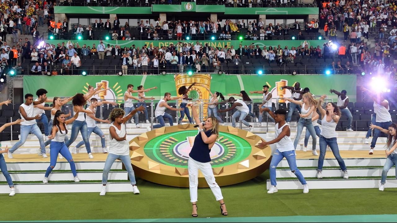 Helene Fischer singt in der Halbzeitpause des DFB-Pokalfinales, im Hintergrund sind Tänzer zu sehen Helene Fischer singt in der Halbzeitpause des DFB-Pokalfinales, im Hintergrund sind Tänzer zu sehen