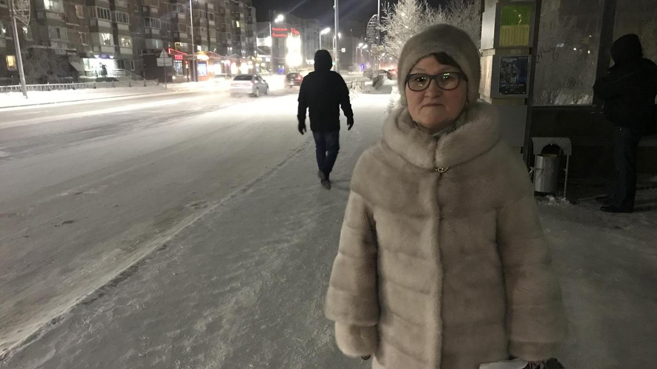 Frau an Bushaltestelle mit Pelzmütze und Pelzmantel Frau an Bushaltestelle mit Pelzmütze und Pelzmantel