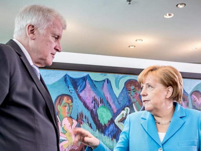 Bundeskanzlerin Angela Merkel (CDU) spricht mit Horst Seehofer (CSU), Bundesminister für Inneres, Heimat und Bau, vor Beginn der Sitzung des Bundeskabinetts im Kanzleramt