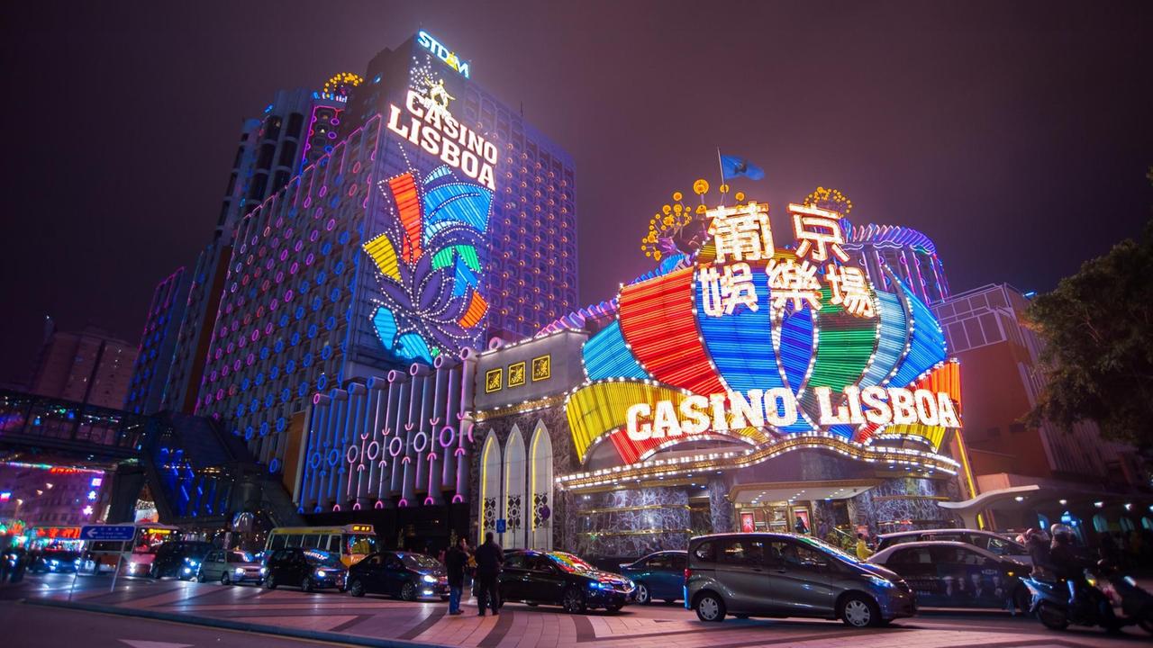 Autos fahren nachts am erleuchteten Casino Lisboa in Macau, China, vorbei, aufgenommen am 12. Februar 2014. Autos fahren nachts am erleuchteten Casino Lisboa in Macau, China, vorbei, aufgenommen am 12. Februar 2014.