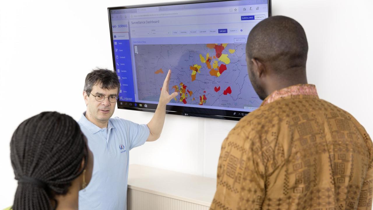Der Epidemiologe Professor Gérard Krause erklärt zwei Mitarbeitern das SORMAS-Dashboard, ein Tool zur Überwachung von Infektionsausbrüchen Der Epidemiologe Professor Gérard Krause erklärt zwei Mitarbeitern das SORMAS-Dashboard, ein Tool zur Überwachung von Infektionsausbrüchen