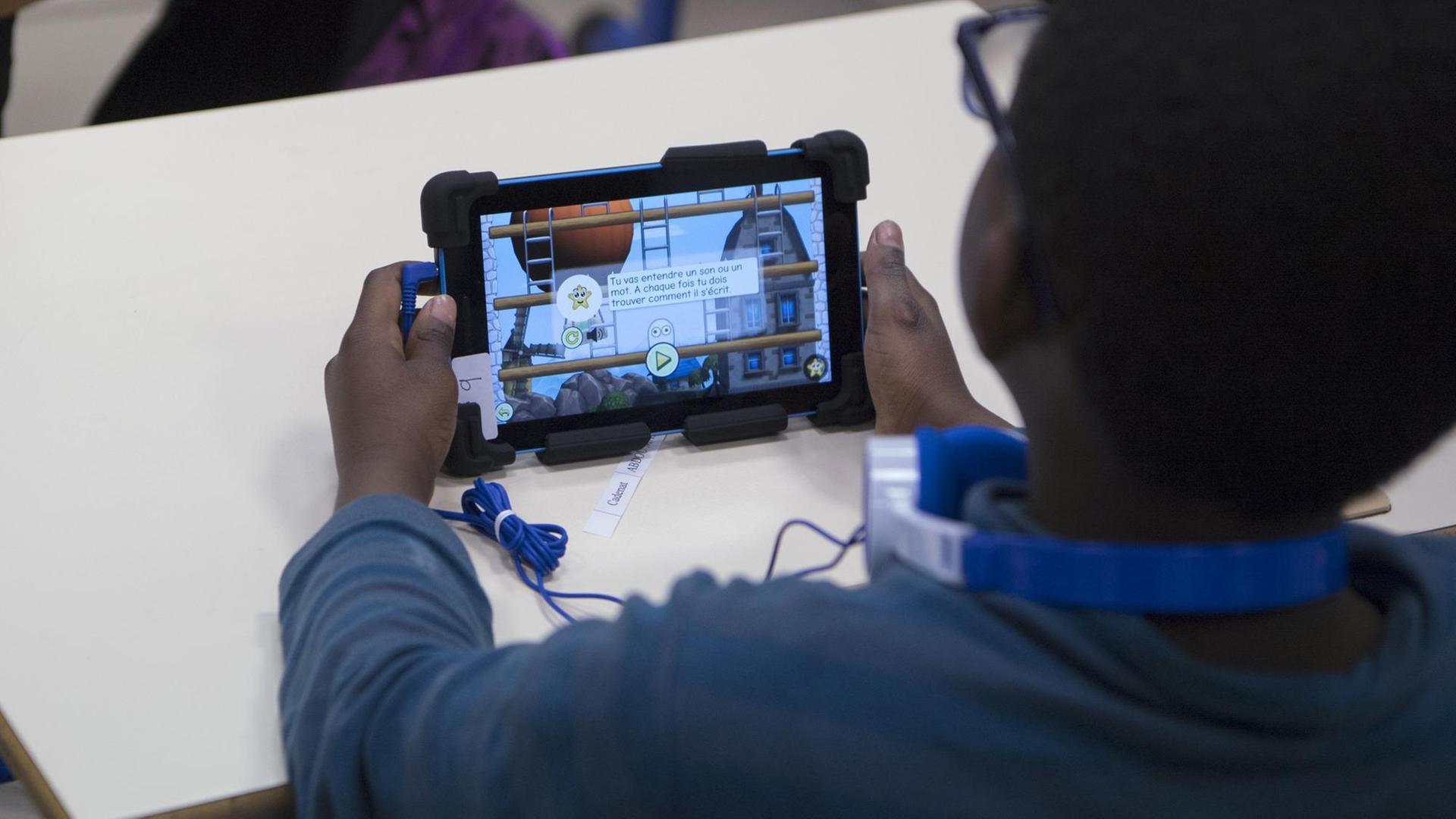 Ein Grundschüler in Marseille mit einem Lernprogramm auf einem Tablet Ein Grundschüler in Marseille mit einem Lernprogramm auf einem Tablet