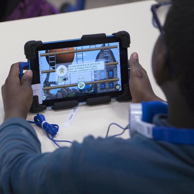 Ein Grundschüler in Marseille mit einem Lernprogramm auf einem Tablet 